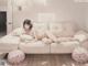 A woman laying on a white couch in a room.