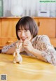 A woman sitting at a table with a stuffed animal.