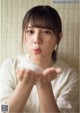 A woman holding a white object in her hands.