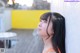 A woman leaning against a wall looking up at the sky.