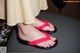 A woman wearing a pair of red flip flops on a table.