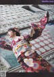 A woman in a kimono is dancing in front of a building.